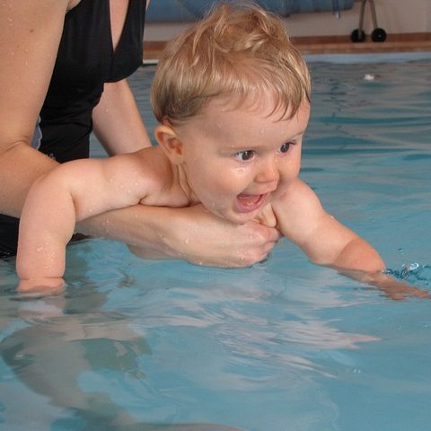 baby swimming with mother